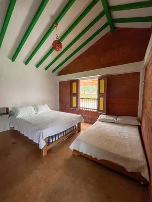 a bedroom with two beds and a brick wall at Finca Hotel Isla del Encanto in Támesis