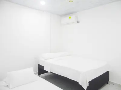 a white room with two beds in it at Apt#202 Descanso familiar en apartamentos vacacionales Bethel in Doradal