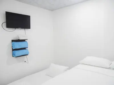 a room with a bed with a tv and towels at Apt#202 Descanso familiar en apartamentos vacacionales Bethel in Doradal