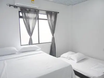 two beds in a room with a window at Apt#202 Descanso familiar en apartamentos vacacionales Bethel in Doradal