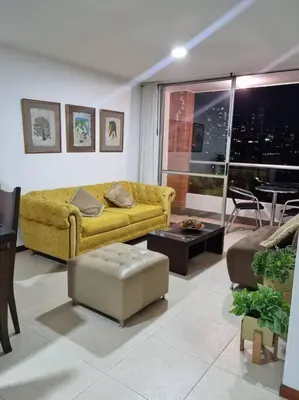 a living room with a yellow couch and a table at El Poblado, Medellín con Piscina, gym, cómodo, linda vista. in Medellín