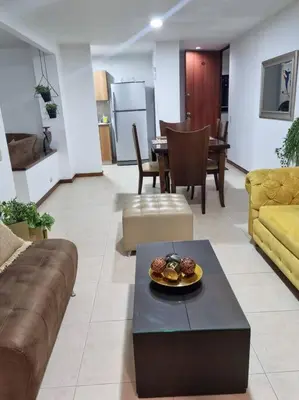 a living room with a couch and a table at El Poblado, Medellín con Piscina, gym, cómodo, linda vista. in Medellín