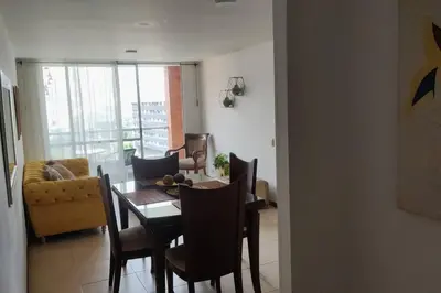 a dining room and living room with a table and chairs at El Poblado, Medellín con Piscina, gym, cómodo, linda vista. in Medellín