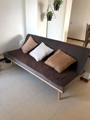 a couch with two pillows on top of it at El Poblado, Medellín con Piscina, gym, cómodo, linda vista. in Medellín