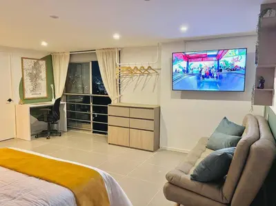 a bedroom with a couch and a tv on the wall at Luxury El Poblado Loft, relax in Medellin's heart! in Medellín
