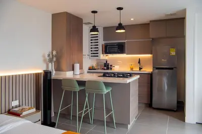 a kitchen with a counter and two bar stools at Luxury El Poblado Loft, relax in Medellin's heart! in Medellín