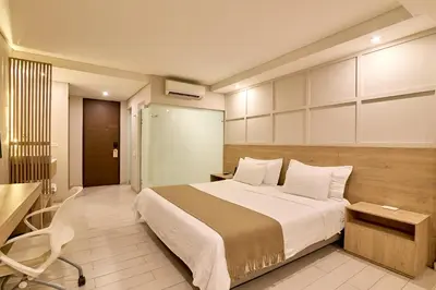 a bedroom with a bed and a desk and a chair at Hotel Dix in Medellín