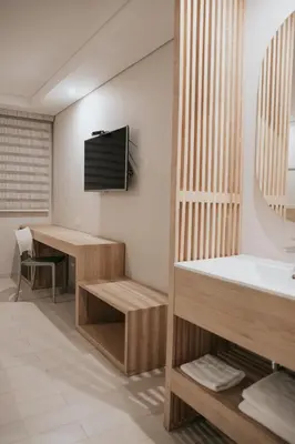 a bathroom with a sink and a television on the wall at Hotel Dix in Medellín