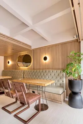 a restaurant with a table and chairs and a bench at Hotel Dix in Medellín
