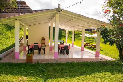 a pavilion with tables and chairs in a yard at Hotel Jardín Del Río in El Bosque