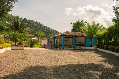 a house with a gravel driveway in front at Hotel Jardín Del Río in El Bosque