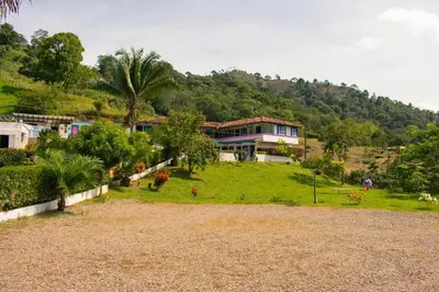 a large house on top of a hill with trees at Hotel Jardín Del Río in El Bosque