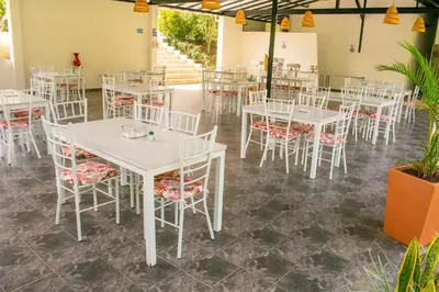 a room with white tables and chairs and plants at Hotel Jardín Del Río in El Bosque