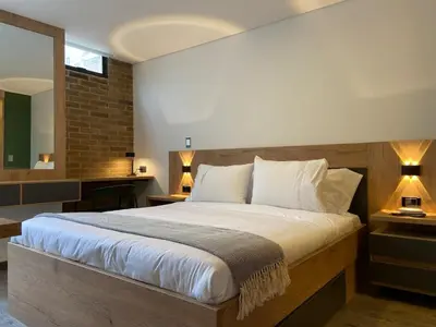 a bedroom with a large bed with two lamps at Ganesh by Wynwood House in Medellín