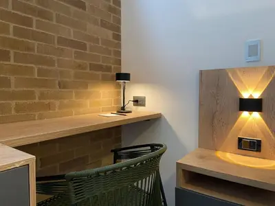 a desk with a lamp and a chair in a room at Ganesh by Wynwood House in Medellín