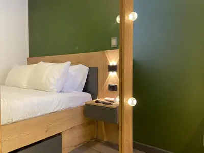 a bedroom with a bed and a green wall at Ganesh by Wynwood House in Medellín