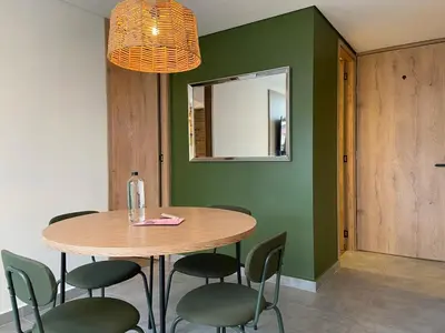 a dining room with a table and chairs and a mirror at Ganesh by Wynwood House in Medellín