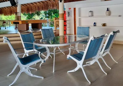 a glass table with blue chairs around it at HOTEL SANTAFE NATURA - SANTAFE DE ANTIQUIA in Santa Fe de Antioquia