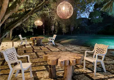 a group of chairs sitting around a wooden table at HOTEL SANTAFE NATURA - SANTAFE DE ANTIQUIA in Santa Fe de Antioquia
