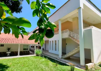a building with a staircase and a grass yard at HOTEL SANTAFE NATURA - SANTAFE DE ANTIQUIA in Santa Fe de Antioquia
