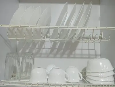a shelf with plates and cups and utensils in a refrigerator at Apartamento cerca a Medellín - Puerta del norte Bello in Machado