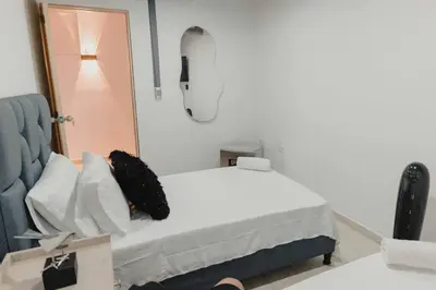 a bedroom with a white bed and a mirror at Laureles Industry Living 4BR in Medellín