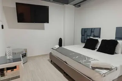 a bedroom with a large bed with a flat screen tv at Laureles Industry Living 4BR in Medellín