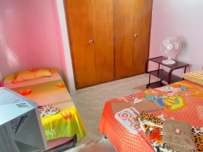 a room with two beds and a tv in it at Hostal Monarca in Medellín
