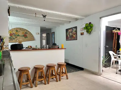 a kitchen with a counter and four stools at Hostal Monarca in Medellín