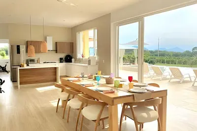 a kitchen and dining room with a wooden table and chairs at Mágica CASA FINCA de lujo piscina privada wi-fi tv in Mariquita