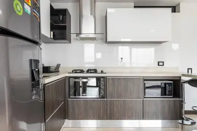 a kitchen with wooden cabinets and a stainless steel refrigerator at 1103 The Overlook of Medellin in El Poblado in Medellín