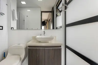 a bathroom with a sink and a toilet and a mirror at 1103 The Overlook of Medellin in El Poblado in Medellín
