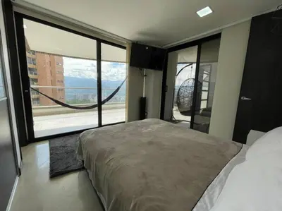 a bedroom with a large bed and a large window at 1103 The Overlook of Medellin in El Poblado in Medellín