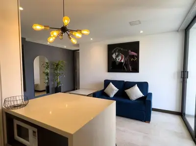 a living room with a blue couch and a ceiling fan at 1201 Luxury Excelente ubicación in Medellín