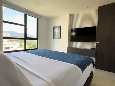 a bedroom with a large bed and a flat screen tv at 1201 Luxury Excelente ubicación in Medellín