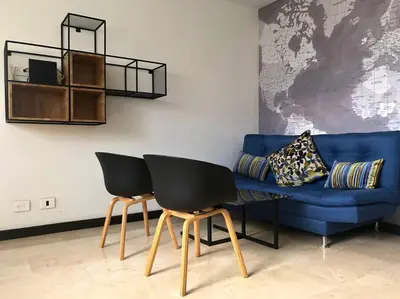 a living room with a blue couch and two chairs at 2004 El Poblado cute and cozy apartment in Medellín