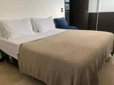 a large bed with white sheets and pillows at 2004 El Poblado cute and cozy apartment in Medellín
