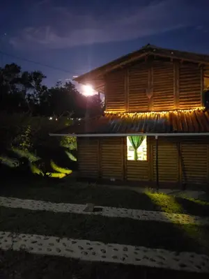 a house with lights on the side of it at night at Cabaña sol de oriente in Marinilla