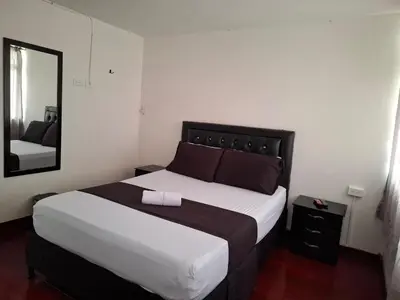 a bedroom with a large bed and a mirror at Hospedaje Luna Llena in Manizales