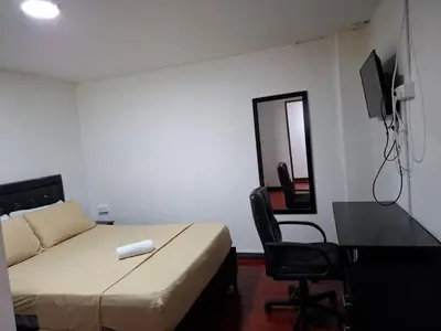 a bedroom with a bed and a desk and a mirror at Hospedaje Luna Llena in Manizales