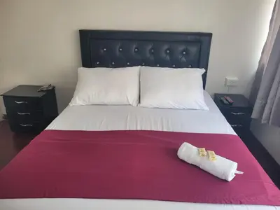 a bed with two towels sitting on top of it at Hospedaje Luna Llena in Manizales