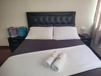 a bedroom with a bed with two slippers on it at Hospedaje Luna Llena in Manizales