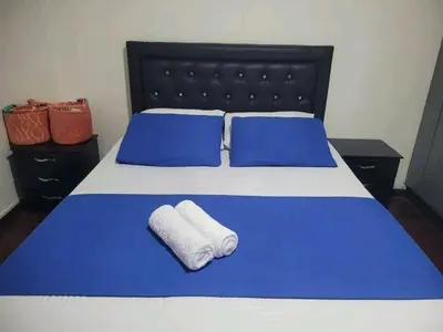 a blue and white bed with two towels on it at Hospedaje Luna Llena in Manizales