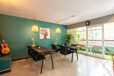 a dining room with two tables and chairs and a guitar at CoNomad House - Coliving & Coworking in Medellín
