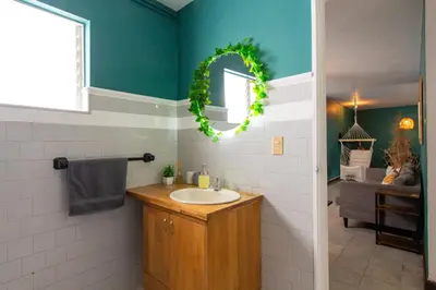 a bathroom with a sink and a wreath on the wall at CoNomad House - Coliving & Coworking in Medellín