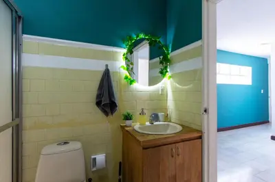 a bathroom with a sink and a mirror and a toilet at CoNomad House - Coliving & Coworking in Medellín
