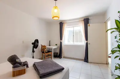 a bedroom with a bed and a desk and a window at CoNomad House - Coliving & Coworking in Medellín