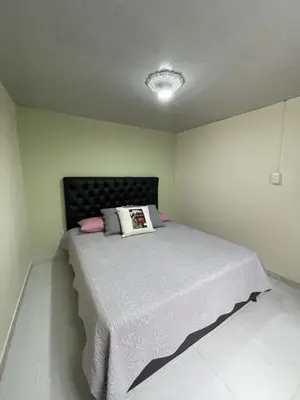 a bedroom with a large bed with a black headboard at APARTAMENTO VACACIONAL in Santa Rosa de Cabal