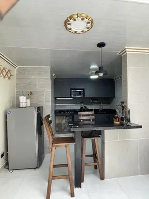 a kitchen with a black counter and a refrigerator at APARTAMENTO VACACIONAL in Santa Rosa de Cabal