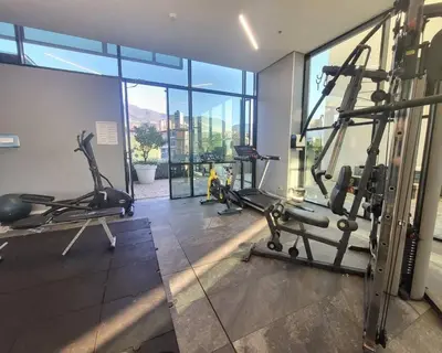 a gym with treadmills and machines in a building at Luxury apt! Guest friendly! Great location! Jacuzzi, Gym, Security! in Medellín
